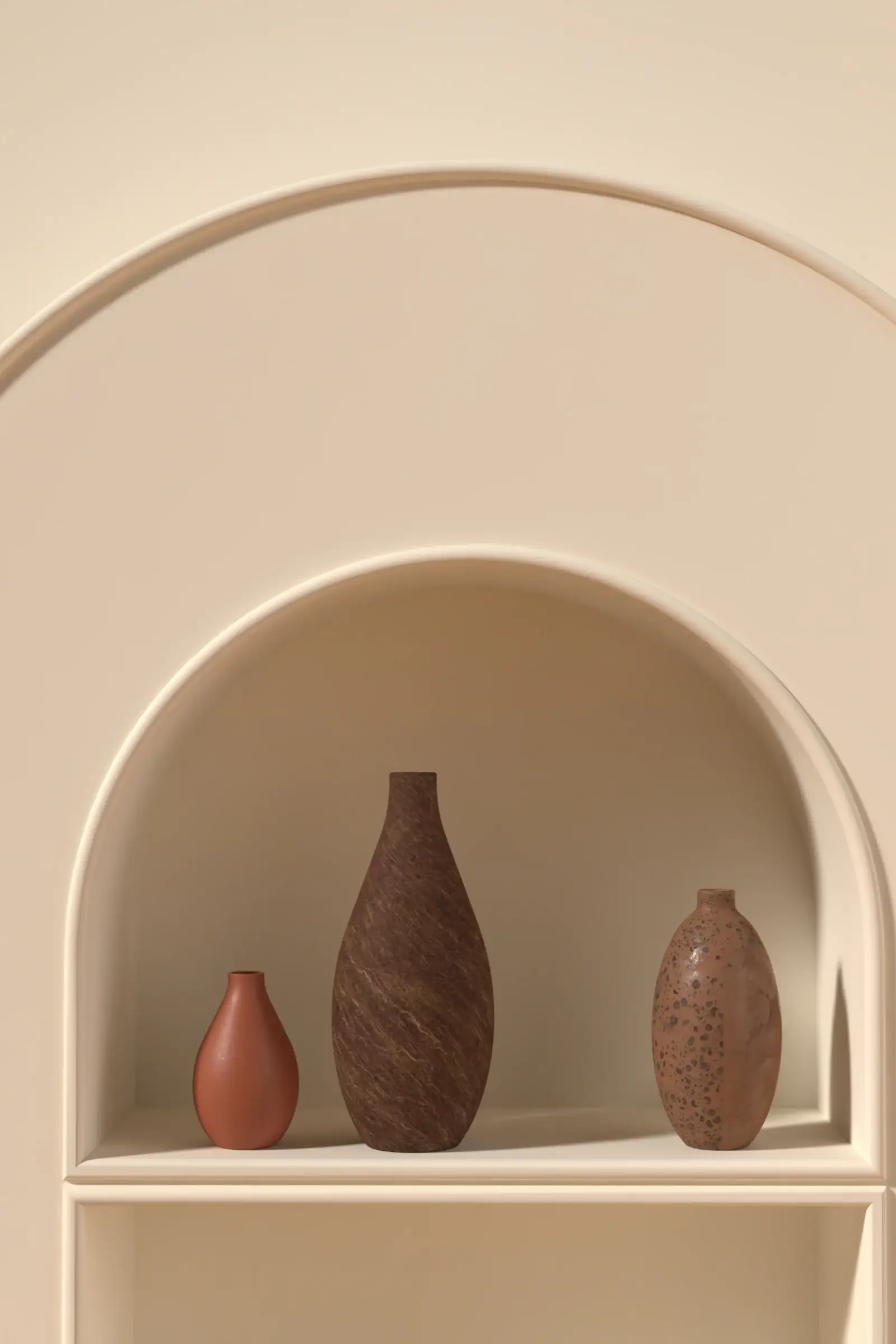 Three sculptural clay vases in a cream arched alcove